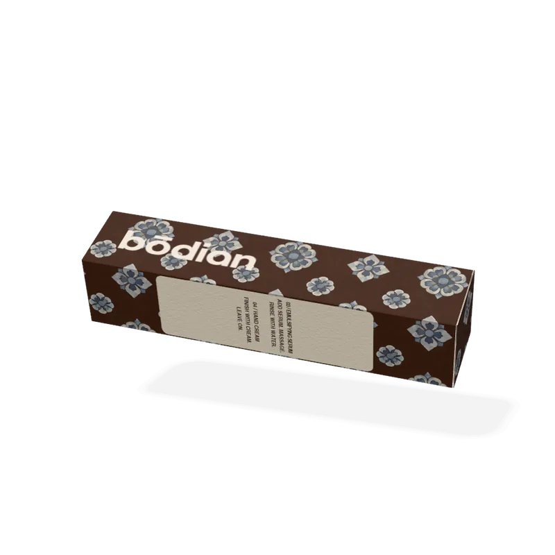 One ritual: the patterned carton that holds its four sachets, blue treasure flowers on coffee brown